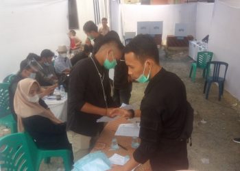 Anggun Pratama (kanan) mengecek TPS usai penutupan pencoblosan.