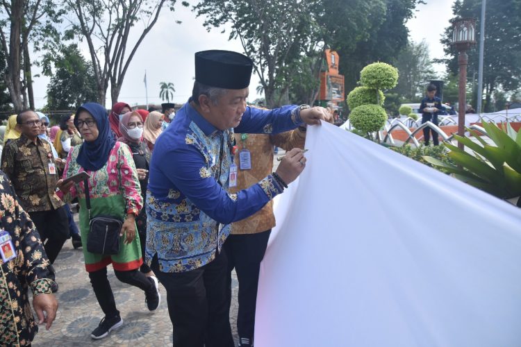 Sekda A Ridwan saat membubuhkan tandatangan tangan di atas kain putih. (Foto : Diskominfo kota Jambi)
