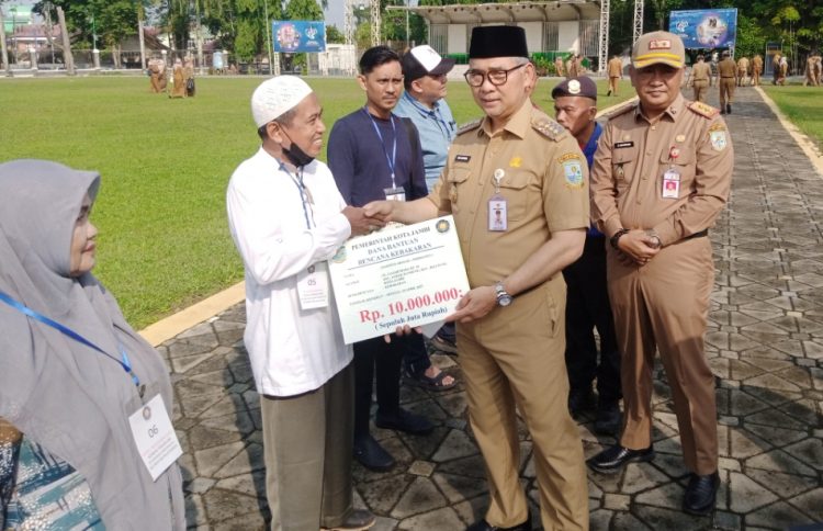 Fasha menyerahkan bantuan korban kebakaran usai apel kedisiplinan ASN. (Foto : Rolan - sinarjambi.com)