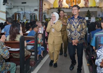 Hujan Deras Tak Surutkan Pj Wali Kota Jambi Tinjau Misa Malam Natal. (Foto : ist)
