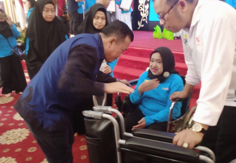 Al Haris memberikan bantuan kursi roda kepada lansia penyandang disabilitas. (Foto : Rolan - sinarjambi.com)