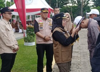 Sri Purwaningsih memasang pengenal kepada perwakilan PTPS kota Jambi. (Foto : Rolan - sinarjambi.com)