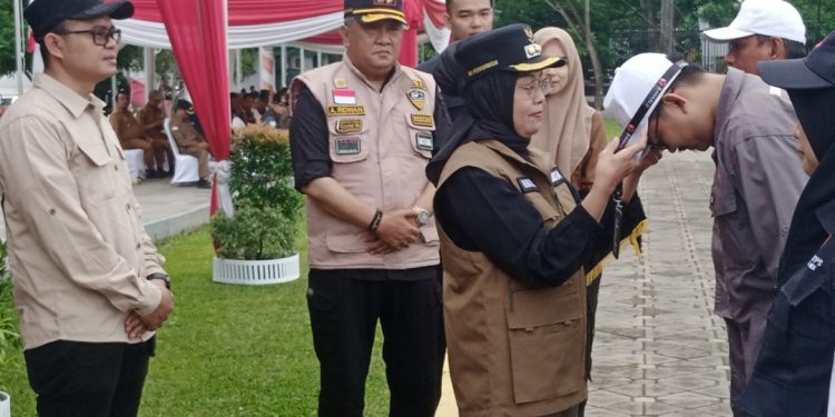 Sri Purwaningsih memasang pengenal kepada perwakilan PTPS kota Jambi. (Foto : Rolan - sinarjambi.com)