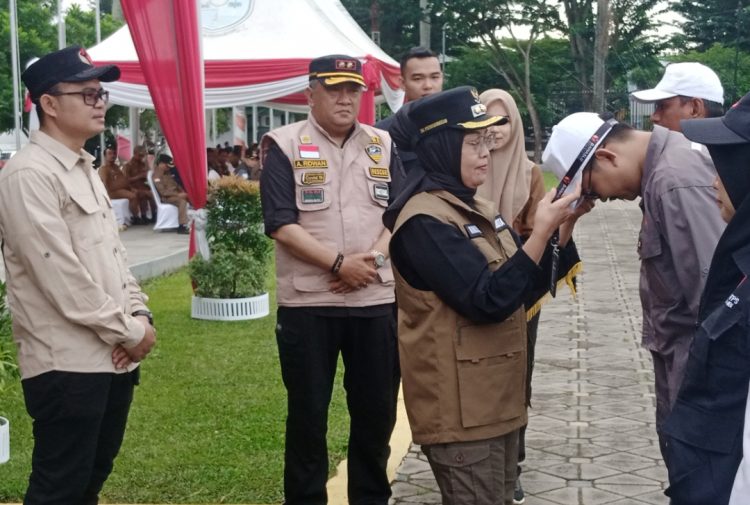 Sri Purwaningsih memasang pengenal kepada perwakilan PTPS kota Jambi. (Foto : Rolan - sinarjambi.com)