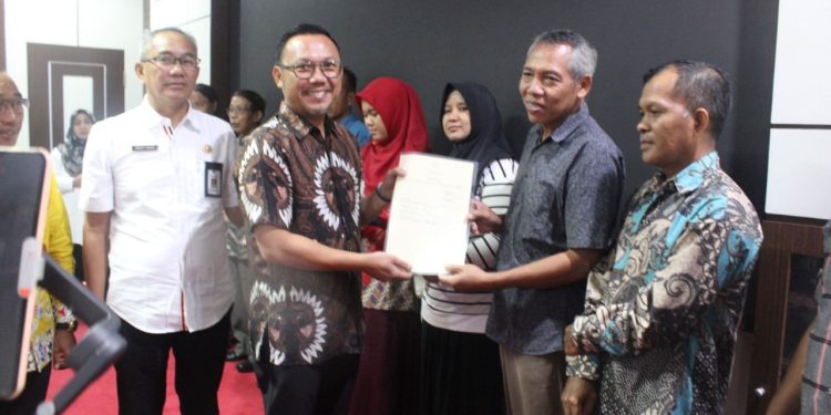 Kepala BPN Kota Palangka Raya Indra Gunawan menyerahkan 10 sertifikat elektronik yang diberikan kepada penerima manfaat, hadir dalam kesempatan tersebut, Pemkot Palangka Raya dan stakeholder terkait. (Foto : BPN Palangka Raya)