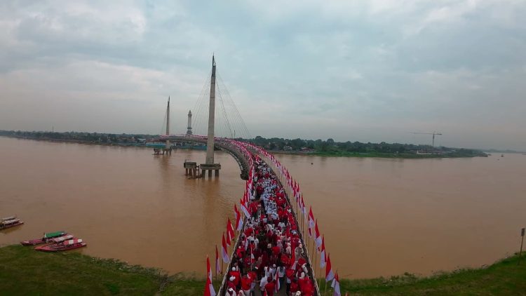 Sejarah Baru! Gubernur Al Haris Raih Rekor MURI Lewat Pengibaran Ribuan Merah Putih di Jembatan Gentala Arasy. (Foto : ist)
